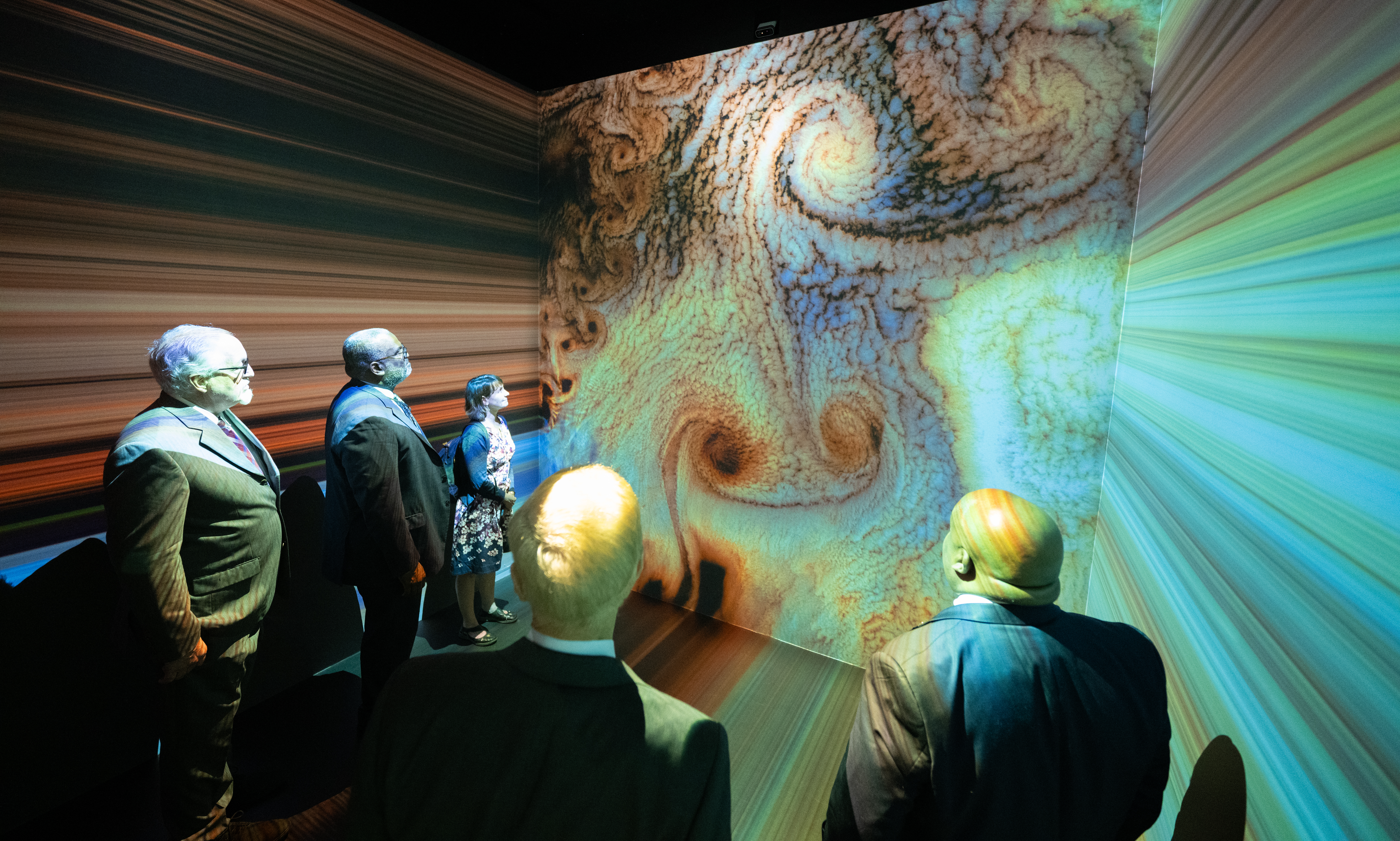 Visitors to NASA HQ enjoying a multi-wall display of satellite imagery.