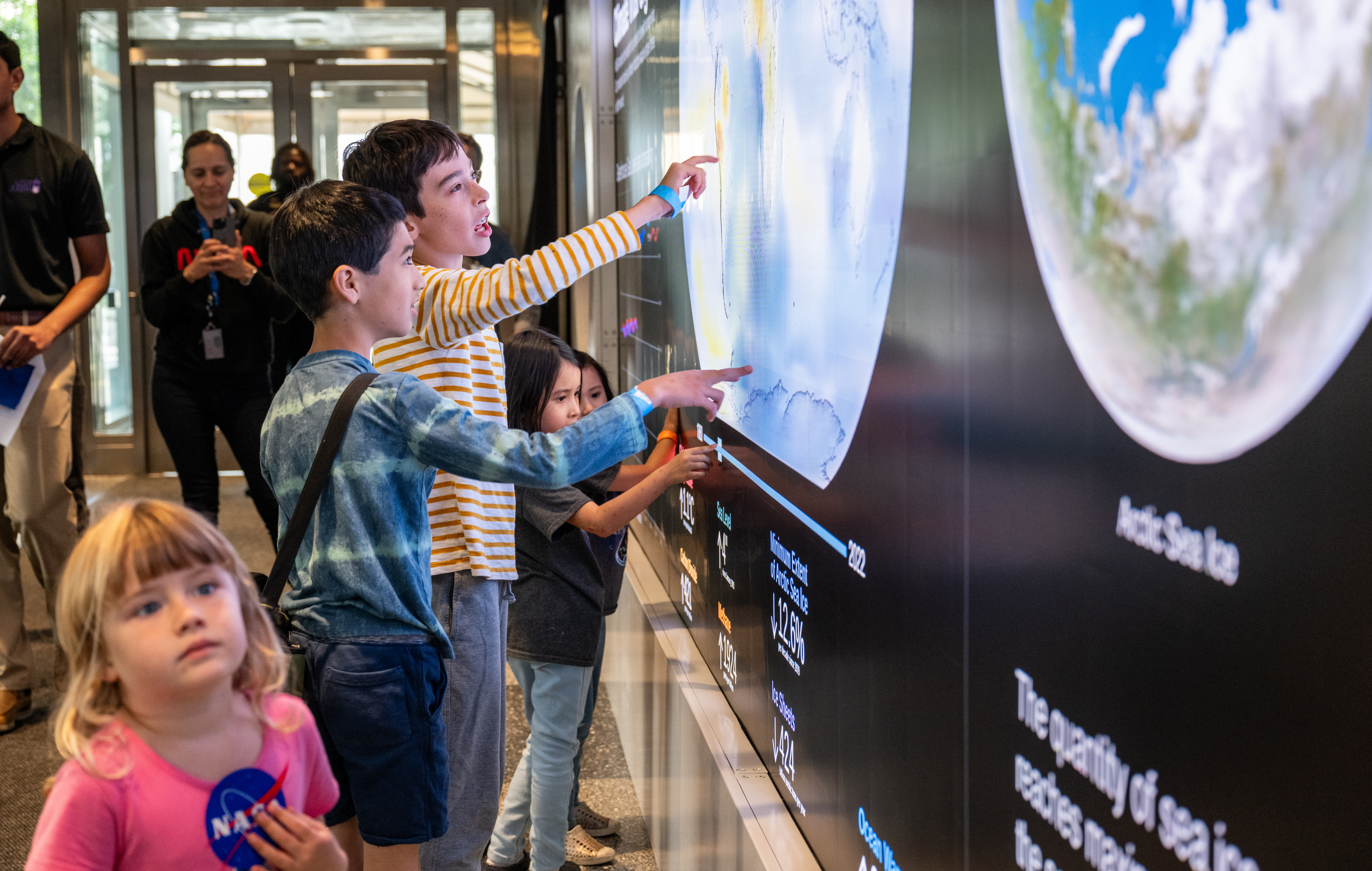 Children interacting with a large panel display at NASA HQ.