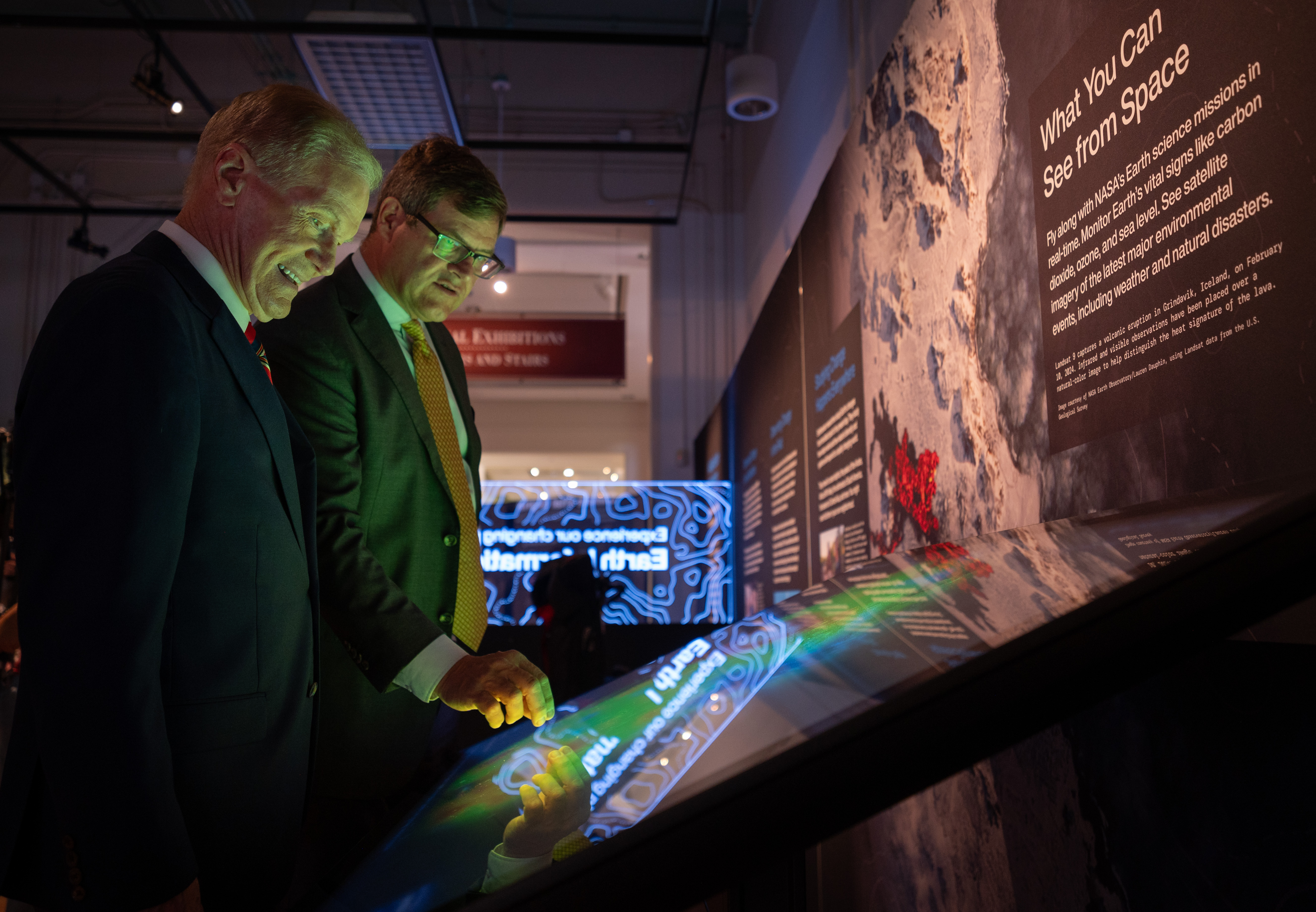 Visitors exploring the live dispaly of Eyes on Earth with smiles on their faces.